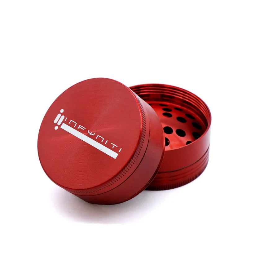 Red Infyniti 50mm zinc grinder with its branded lid lifted beside the grinding section