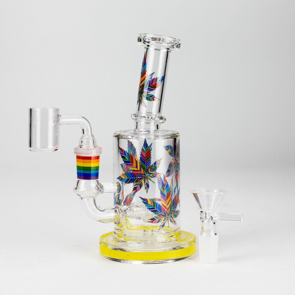 Yellow-base leaf print dab rig with rainbow-trim banger joint and included glass bowl alongside