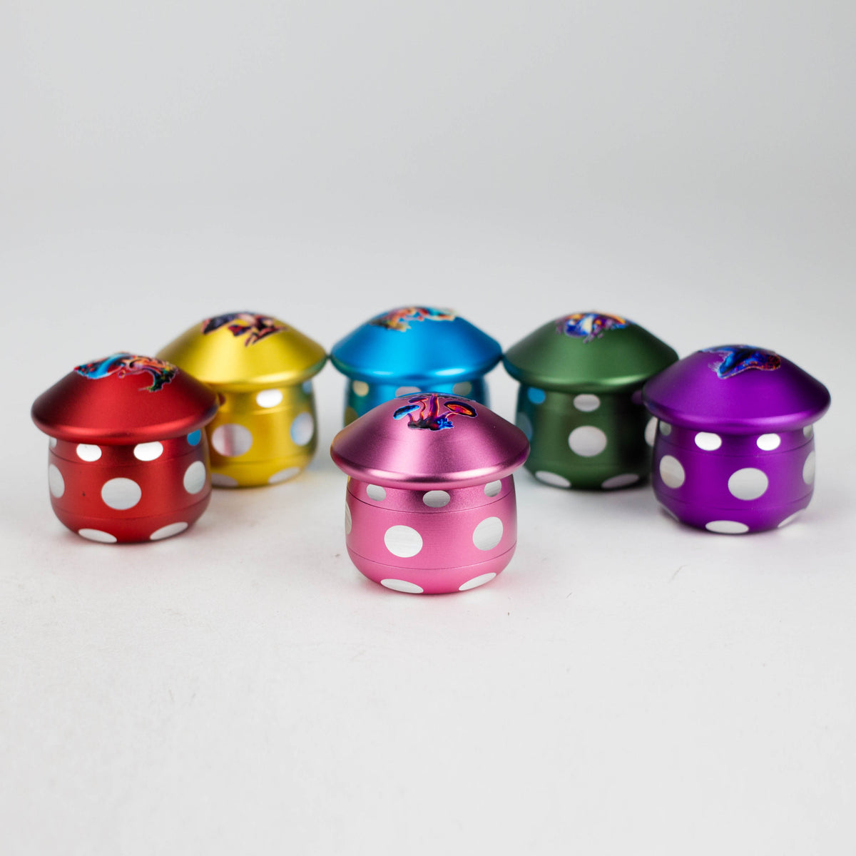 Six mushroom-shaped aluminium herb grinders in red, yellow, blue, green, purple and pink