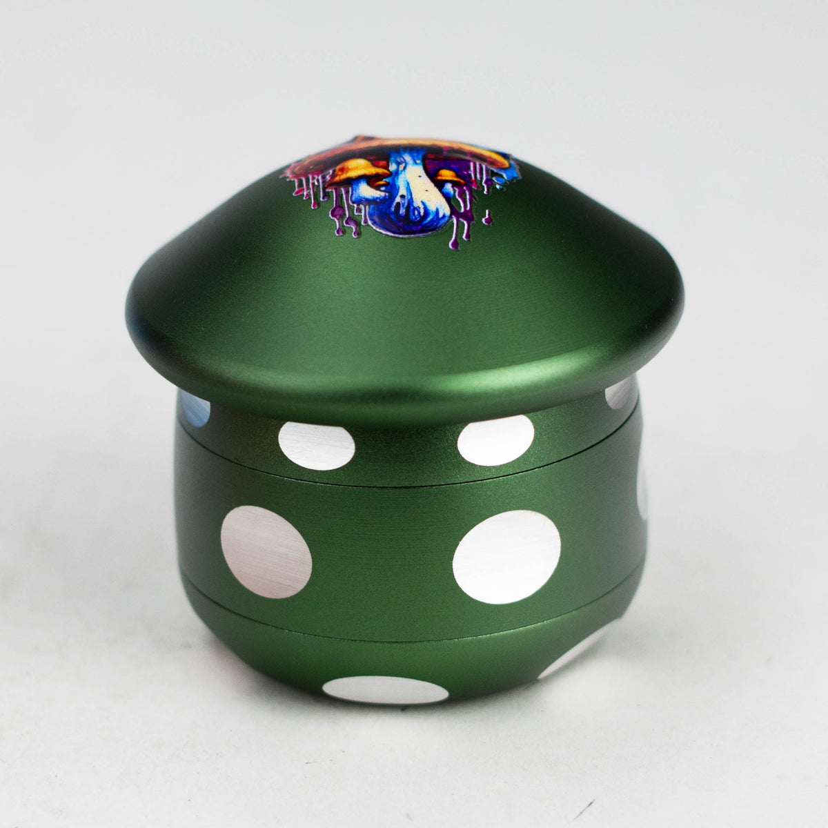 Green aluminium mushroom herb grinder with white spots and orange-blue mushroom cap art