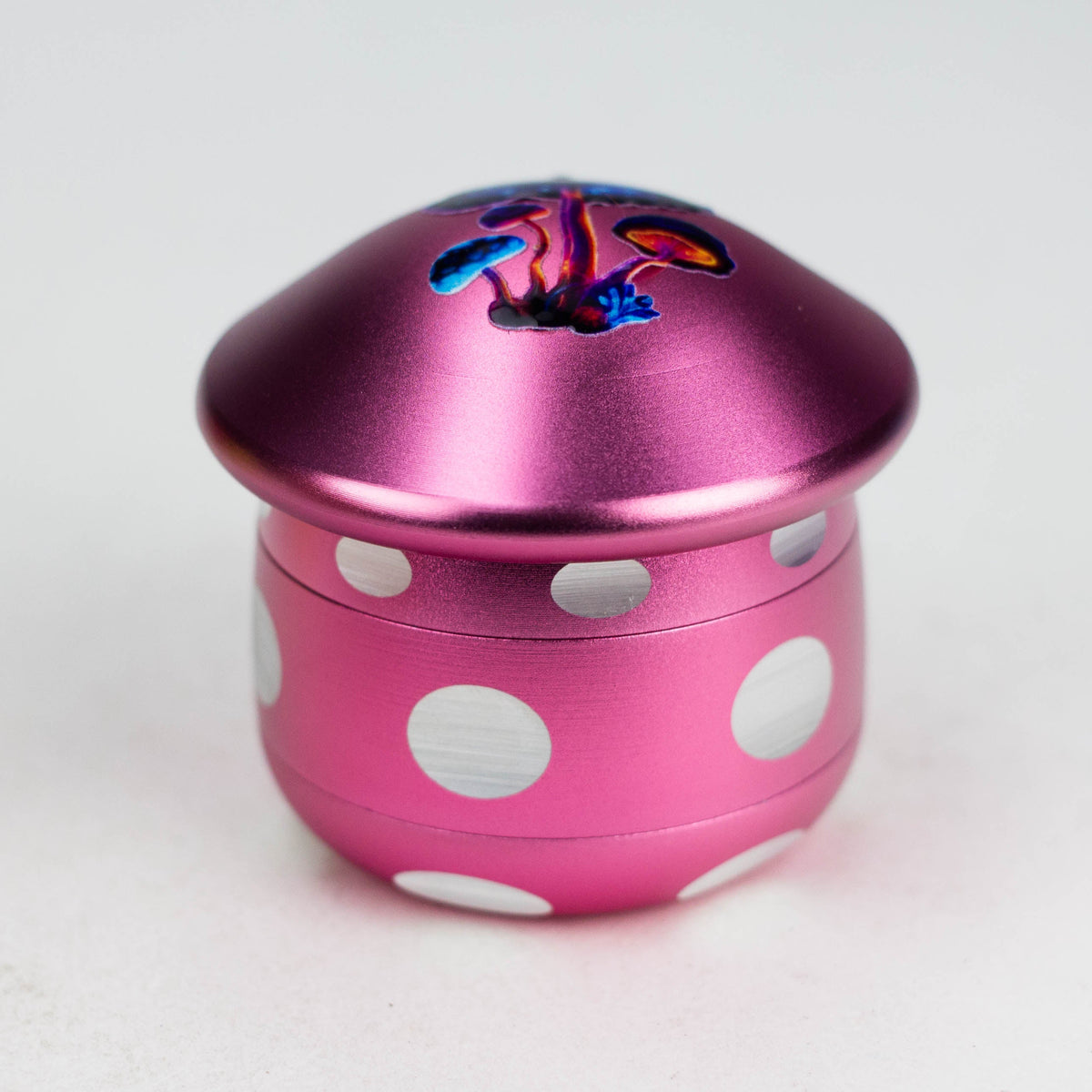 Pink four-piece mushroom herb grinder with white spots and colourful cap artwork