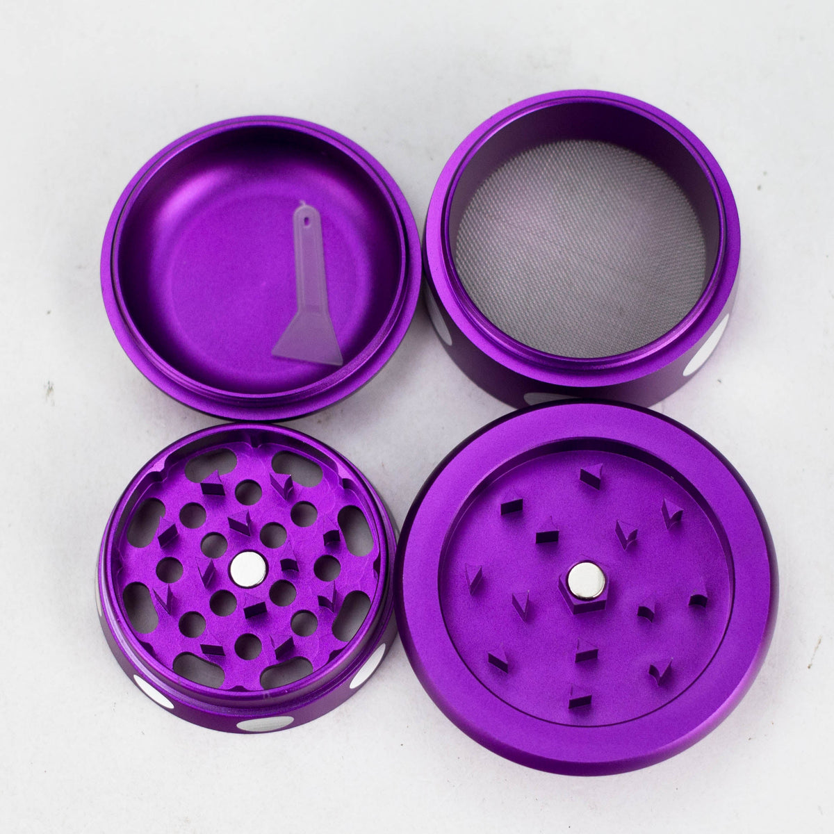 Purple mushroom grinder separated into four pieces showing teeth, pollen screen and scraper