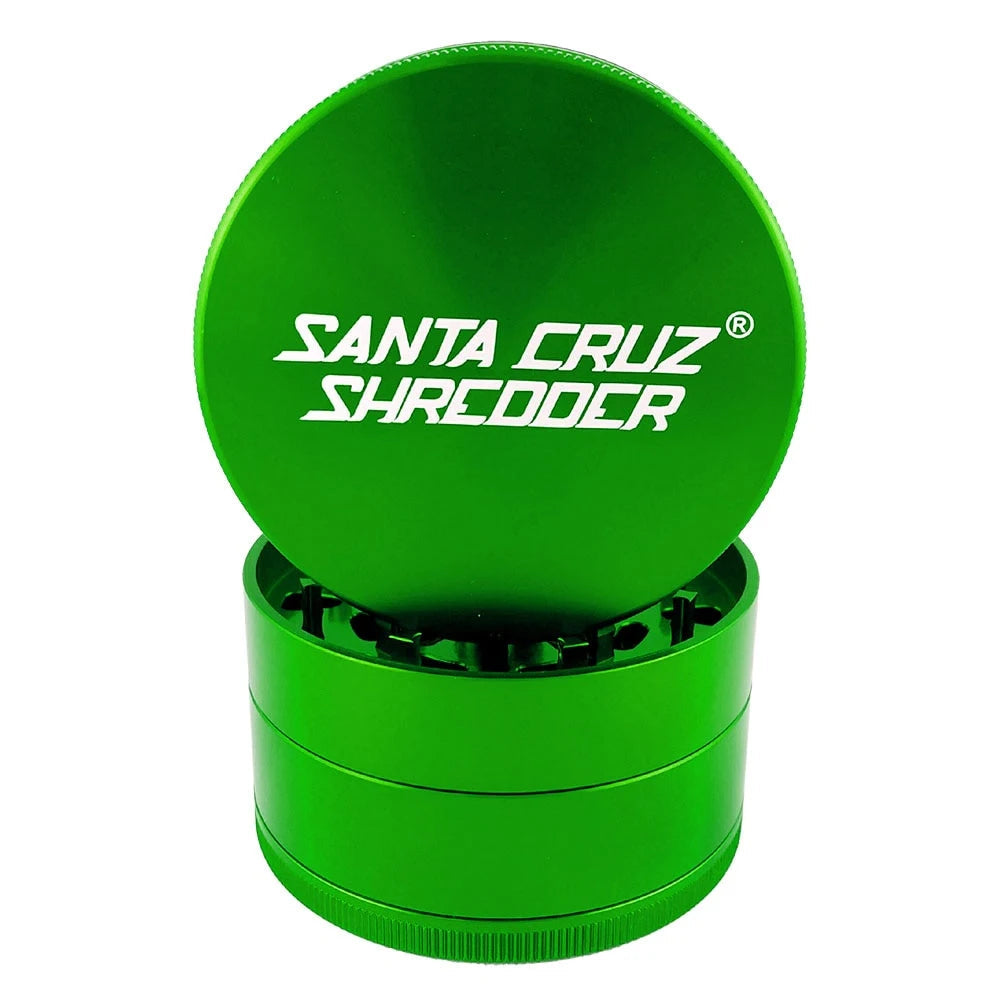Green Santa Cruz Shredder large four-piece grinder with logo lid propped above the teeth