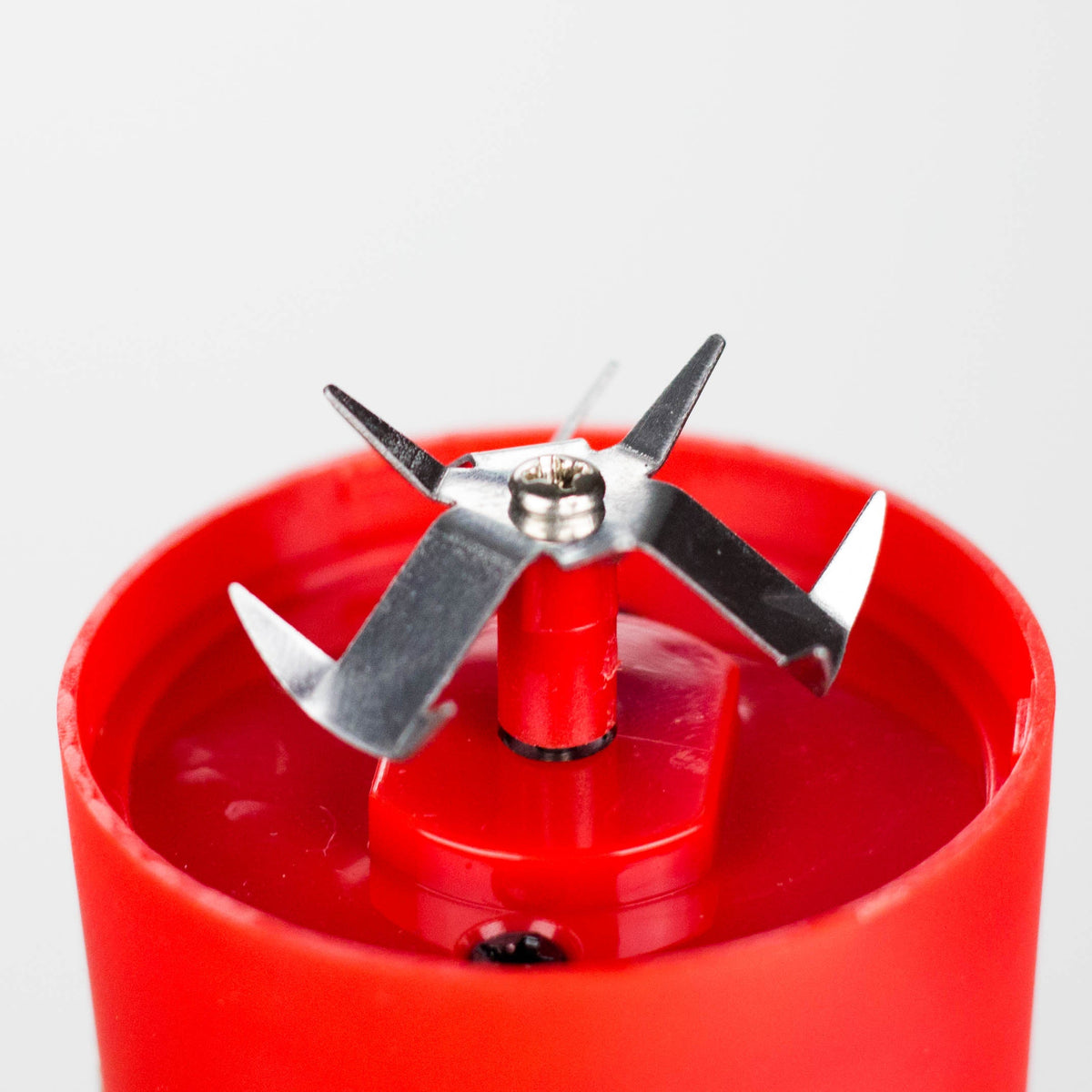 Close-up of the electric grinder’s metal cutting blades inside the Red body