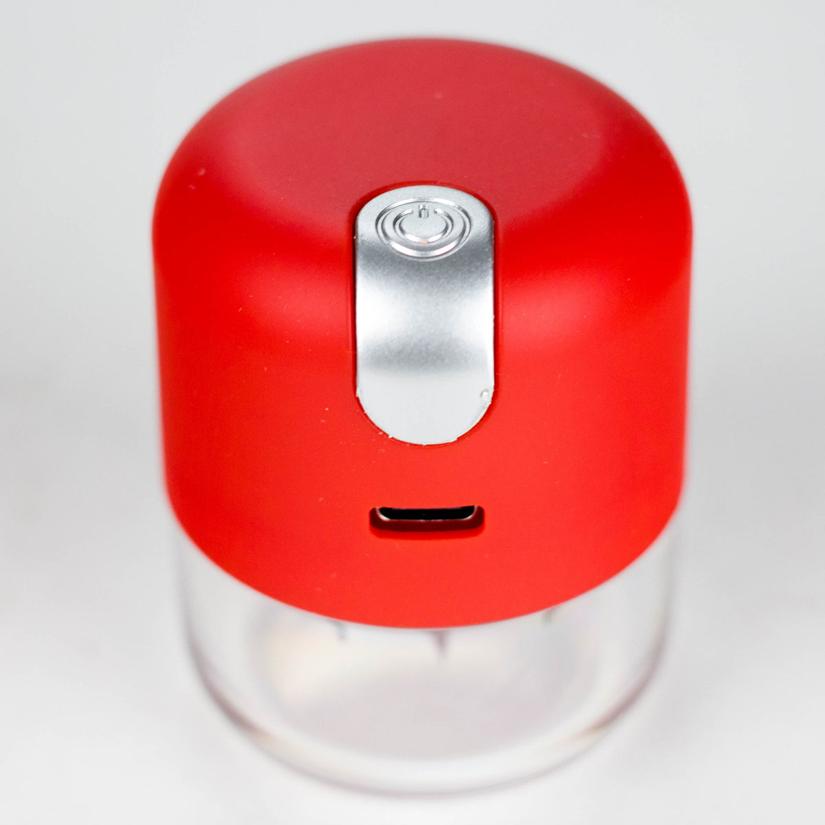Red USB rechargeable herb grinder with silver button, charging port and clear lower chamber
