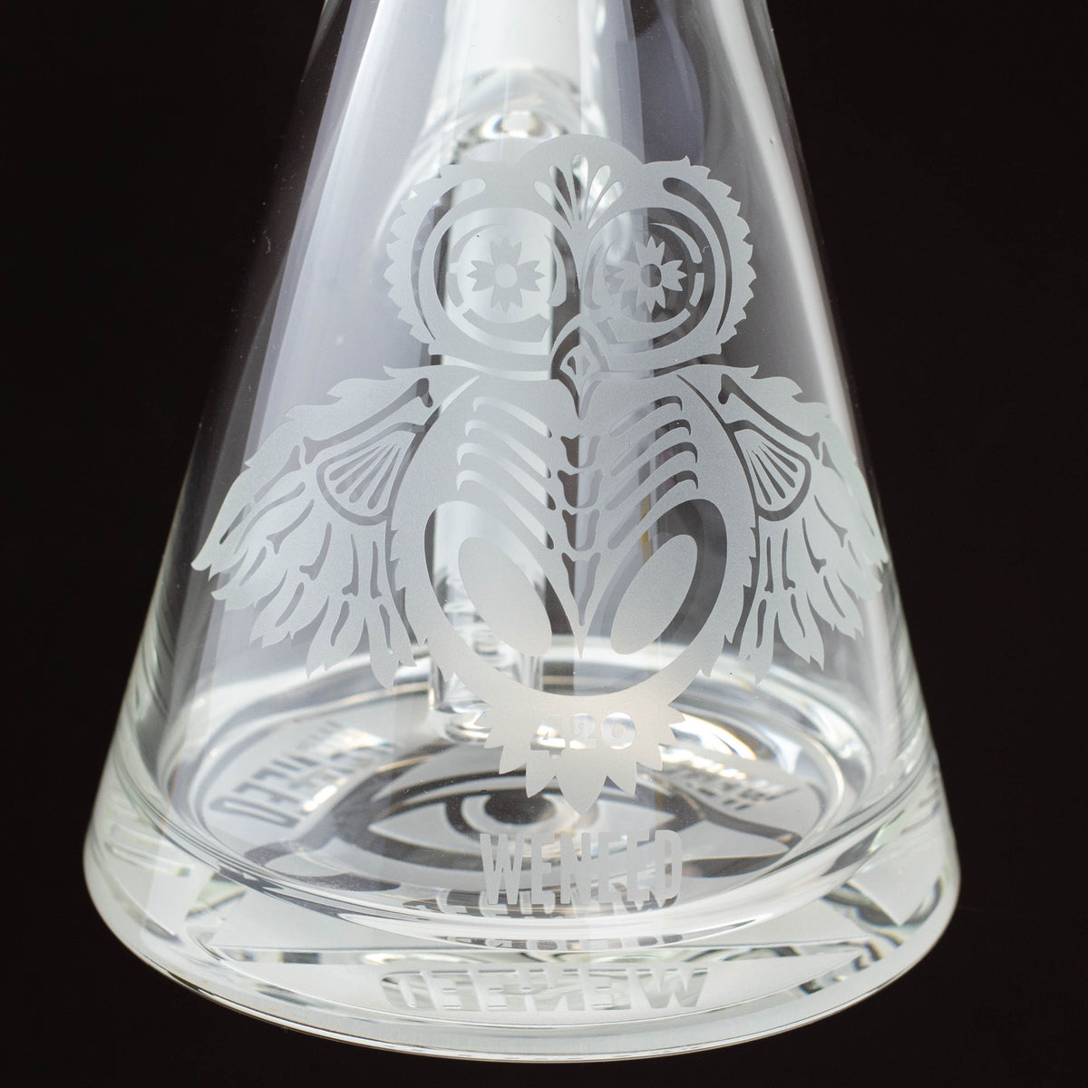 Up-close view of WENEED® 15-inch glass beaker bong base with owl engraving.